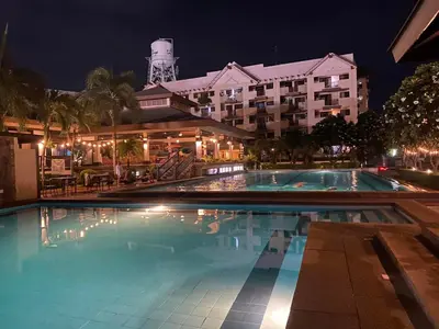 a swimming pool in front of a hotel at night at 3 bedroom 89sqm midrise condotel in Manila