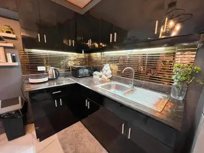 a kitchen with black cabinets and a sink at 3 bedroom 89sqm midrise condotel in Manila