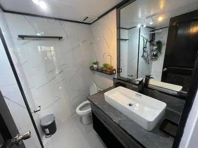 a white bathroom with a sink and a toilet at 3 bedroom 89sqm midrise condotel in Manila