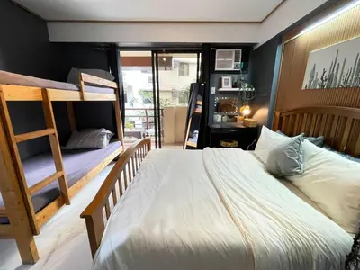 a bedroom with two bunk beds and a balcony at 3 bedroom 89sqm midrise condotel in Manila