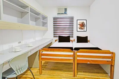 a small bedroom with a bed and a desk at Townhouse College Residences in University Belt, Metro Manila in Manila
