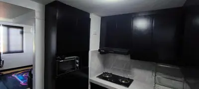 a black kitchen with black cabinets and a sink at DPMC Stay and Play Vacation Unit in Cainta