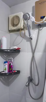 a bathroom with a shower head and a fan at DPMC Stay and Play Vacation Unit in Cainta