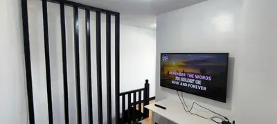 a living room with a tv on a wall at DPMC Stay and Play Vacation Unit in Cainta