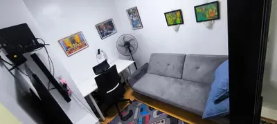 a living room with a couch and pictures on the wall at DPMC Stay and Play Vacation Unit in Cainta