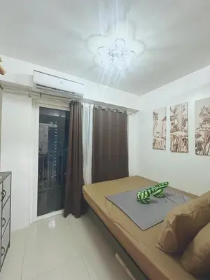 a small bedroom with a bed and a window at SHORE RESIDENCES NEAR Moa in Manila