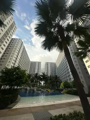 a large swimming pool in a city with tall buildings at SHORE RESIDENCES NEAR Moa in Manila