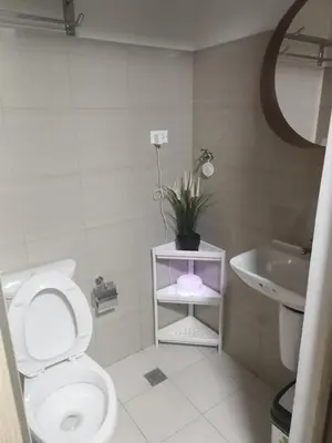 a bathroom with a toilet and a sink and a plant at Shore2n3 Residences MOA Pasay City Near NAIA Airport in Manila