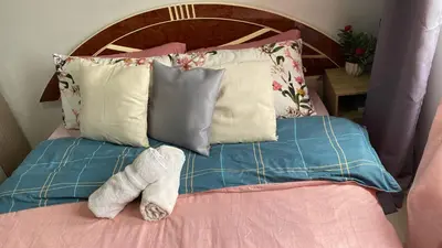 a teddy bear laying on a bed with pillows at Collins Condotel in Manila