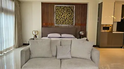 a living room with a couch and a bed at Poblacion Studio Apartment with Balcony in Manila