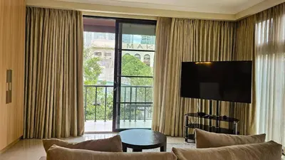 a living room with a couch and a large window at Poblacion Studio Apartment with Balcony in Manila
