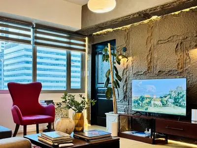 a living room with a red chair and a television at 2BR in Central BGC in Manila