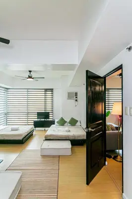 a room with two beds and a living room at 2BR in Central BGC in Manila