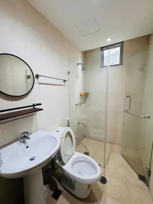 a bathroom with a sink and a toilet and a shower at 2BR in Central BGC in Manila