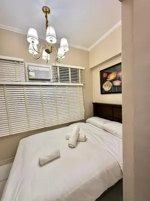 a bedroom with a large white bed with two towels on it at Studio Two Condominium, Alabang AMBER -Fiber WI-FI Netflix ready in Manila