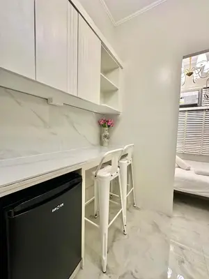 a kitchen with a white counter and a table and chairs at Studio Two Condominium, Alabang Northgate Cyberzone, DOVE-Fiber Wi-Fi Netflix ready in Manila