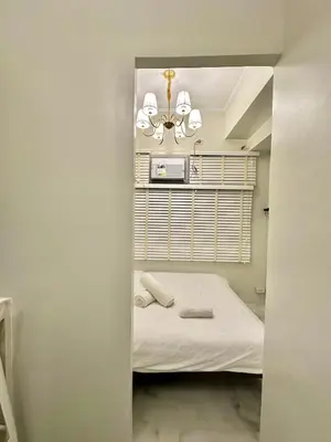 a small bedroom with a bed and a mirror at Studio Two Condominium, Alabang Northgate Cyberzone, DOVE-Fiber Wi-Fi Netflix ready in Manila