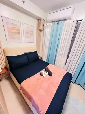 a bedroom with a bed with two stuffed animals on it at Cozy Suite Pool View in Shore 2 Residences near SM MOA in Manila