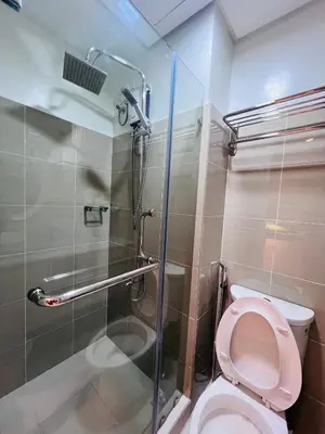 a bathroom with a pink toilet and a shower at Cozy Suite Pool View in Shore 2 Residences near SM MOA in Manila