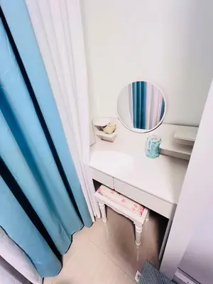 a dressing table with a mirror and a stool at Cozy Suite Pool View in Shore 2 Residences near SM MOA in Manila