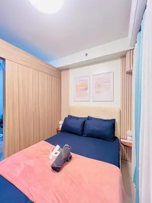 a bedroom with a bed with a pair of shoes on it at Cozy Suite Pool View in Shore 2 Residences near SM MOA in Manila