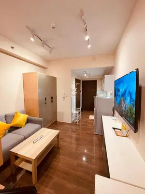 a living room with a couch and a tv on a wall at Destina, 100Mbps at Air Residences, Makati, MetroManila, Netflix in Manila