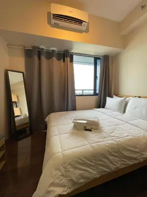 a bedroom with a large white bed and a mirror at Destina, 100Mbps at Air Residences, Makati, MetroManila, Netflix in Manila