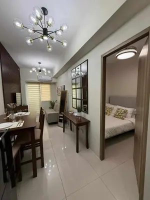 a living room with a bed and a dining room at Stylish and Comfy Condominium in Manila