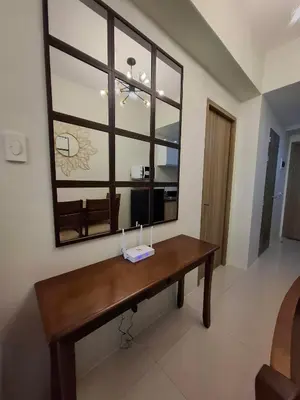 a wooden bench in a room with a large window at Stylish and Comfy Condominium in Manila