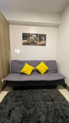 a bed in a room with two yellow pillows at Staycation Bliss at Fame in Manila