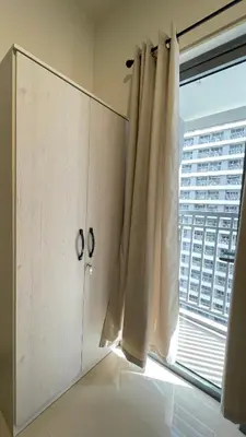 a white cabinet with a window with a view at Staycation Bliss at Fame in Manila