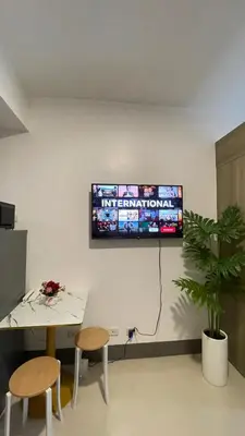 a living room with a tv on the wall at Staycation Bliss at Fame in Manila