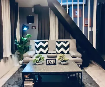 a living room with a couch and a coffee table at Cloves Den Binangonan Your Ultimate Cinema Date in Binangonan