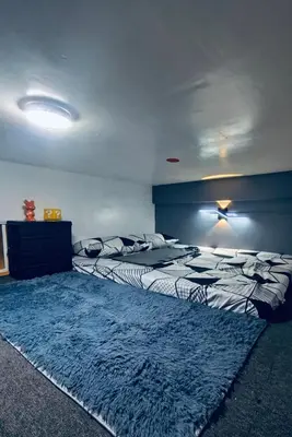 a bedroom with two beds and a rug at Cloves Den Binangonan Your Ultimate Cinema Date in Binangonan