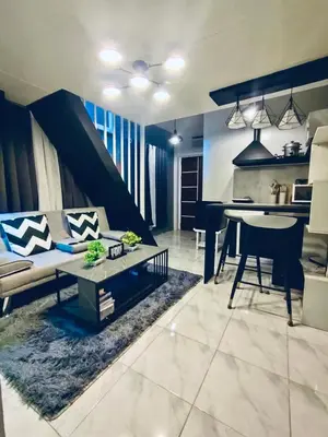 a living room with a couch and a table at Cloves Den Binangonan Your Ultimate Cinema Date in Binangonan