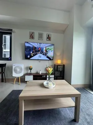 a living room with a table and a flat screen tv at M S Staycation in Manila