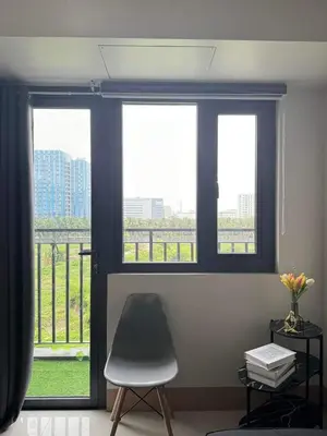 a room with three windows with a chair and a balcony at M S Staycation in Manila