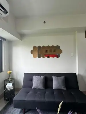 a living room with a couch and a bear on the wall at M S Staycation in Manila
