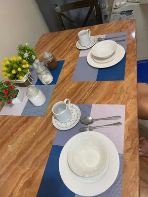 a wooden table with white plates and dishes on it at Big cut room 3beds 1103 tower A in Manila