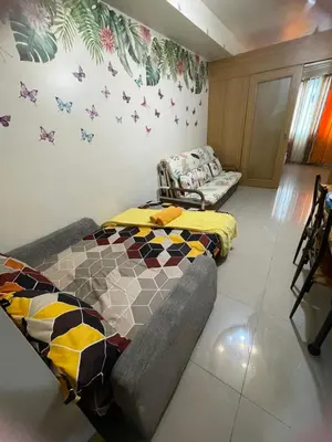 a living room with a couch and butterflies on the wall at Big cut room 3beds 1103 tower A in Manila