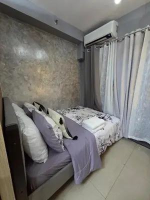 a bedroom with a bed with white pillows at Cozy Corner at Shore 2 in Manila