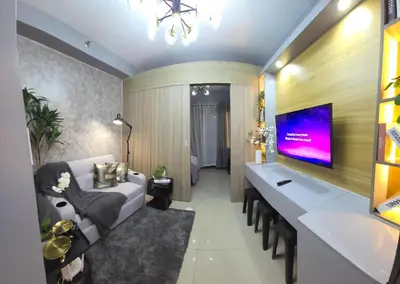 a living room with a couch and a tv at Cozy Corner at Shore 2 in Manila