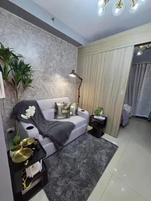 a living room with a couch and a table at Cozy Corner at Shore 2 in Manila