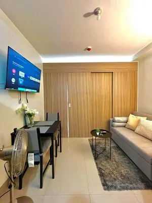 a living room with a couch and a tv on the wall at Staycation Shore 2 Residences Tower 2 Pasay City in Manila