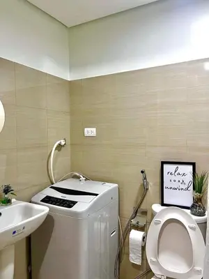 a bathroom with a washing machine and a sink at Staycation Shore 2 Residences Tower 2 Pasay City in Manila