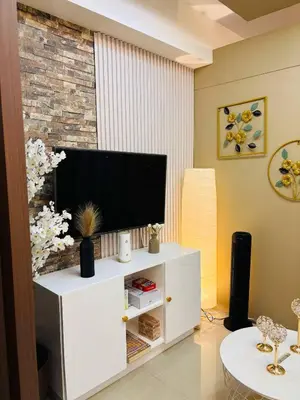 a living room with a flat screen tv on a white cabinet at SMDC SHORE 1 Residences, TOWER A in Manila