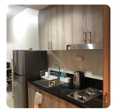 a kitchen with a sink and a refrigerator at Shore Residences Apartment Condo Staycation in Manila