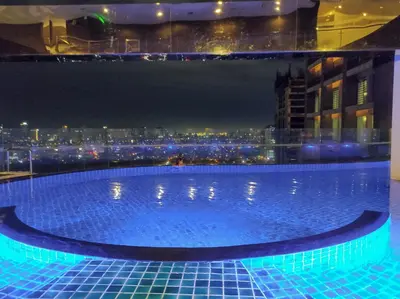 a swimming pool on the roof of a building with a city at High Sunset View with Fast WiFi, Pool, Big Balcony, Gym Access in Manila