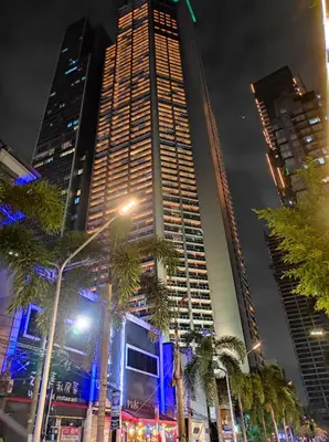 a tall building with palm trees in front of it at High Sunset View with Fast WiFi, Pool, Big Balcony, Gym Access in Manila