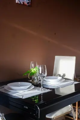 a table with plates and wine glasses on it at High Sunset View with Fast WiFi, Pool, Big Balcony, Gym Access in Manila